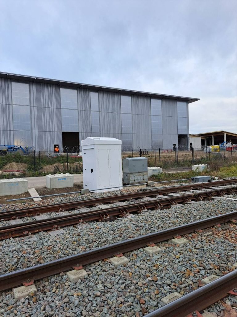 SafeBox RT signalling cabinet trackside in front of a depot building