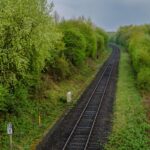 Railway tracks curve through lush greenery.