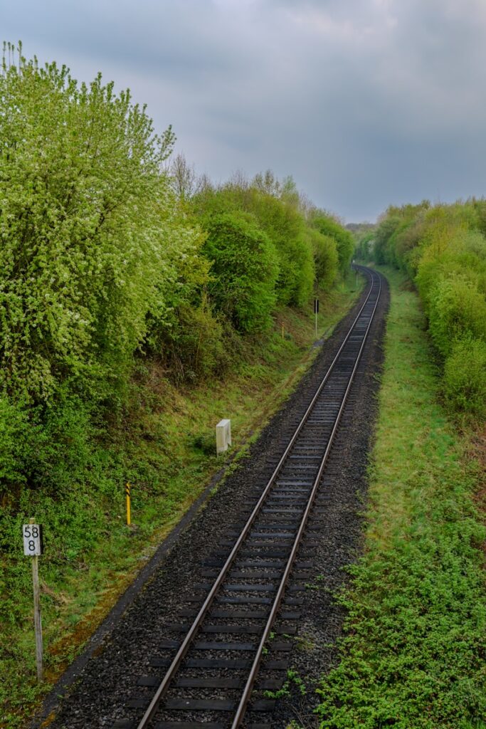 Railway tracks curve through lush greenery.